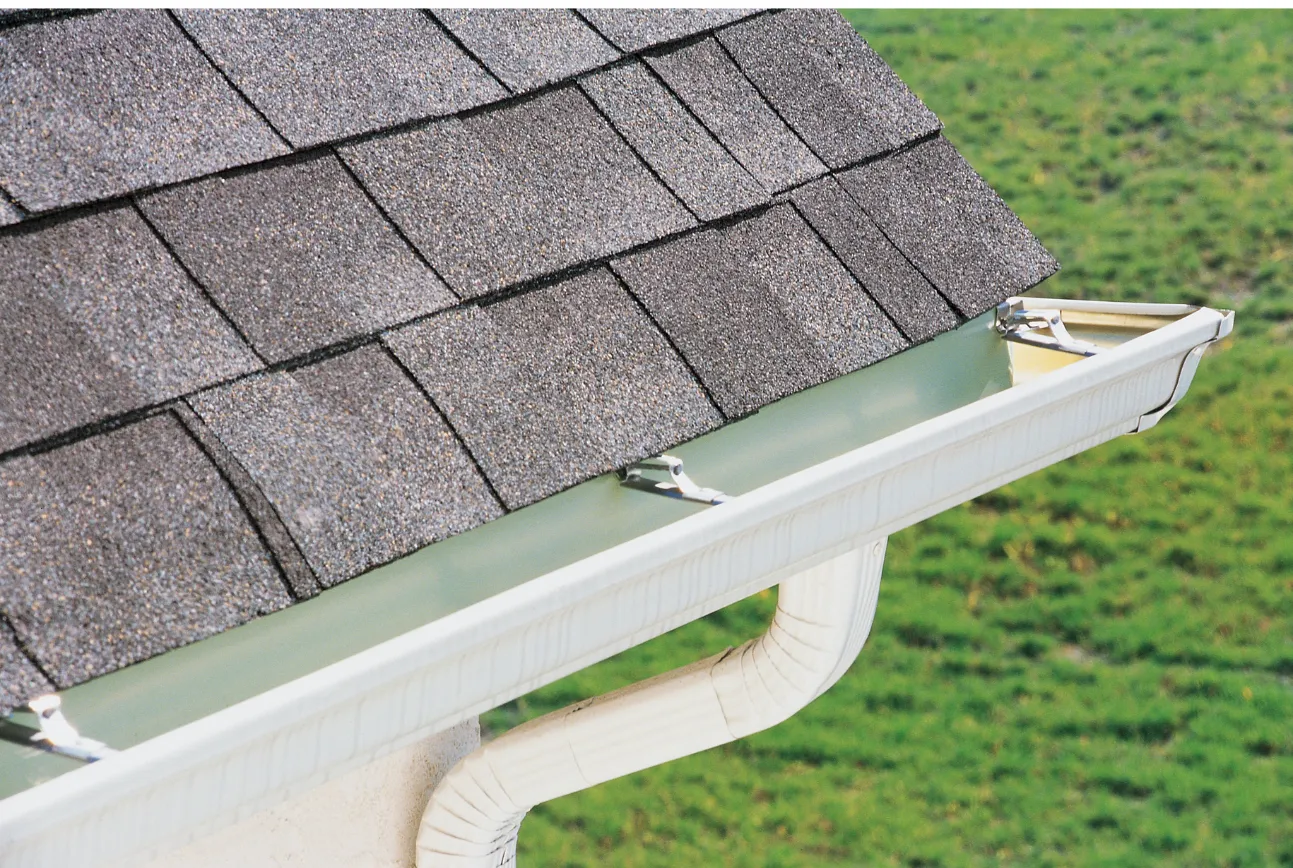 A picture of the corner of a roof with white gutters on it in Mandeville, LA.